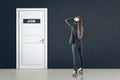 Businesswoman looking on white door with job sign Royalty Free Stock Photo