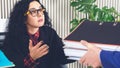 Stressed woman doing late at work with a lot of papers, piles of documents, computer. Office work, work load