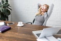 businesswoman lying on chair with hands behind head coffee cup Royalty Free Stock Photo