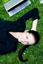 Businesswoman lying on grass