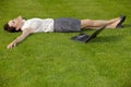 Businesswoman lying in park with laptop