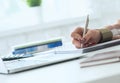 Hands of female financial manager taking notes when working on report. Businesswoman makes thoughts records at personal