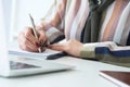 Hands of female financial manager taking notes when working on report. Businesswoman makes thoughts records at personal