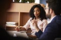 Businesswoman Making Notes Sitting At Table Meeting With Colleagues In Modern Office