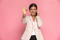 Businesswoman making an ok sign while talking on the phone Royalty Free Stock Photo