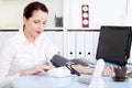 Businesswoman measuring her blood pressure.