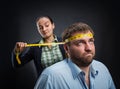 Businesswoman measuring man's head