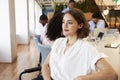 Businesswoman In Modern Office With Colleagues Meeting Around Table In Background