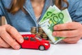 Businesswoman with money and toy red car in hands Royalty Free Stock Photo