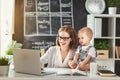 Businesswoman mother woman with toddler working at computer