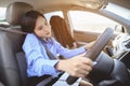 Businesswoman multitasking while driving car working and talking on cell phone on the road. Royalty Free Stock Photo