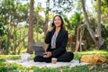 A businesswoman is multitasking, talking on the phone and working on her digital tablet in a park Royalty Free Stock Photo