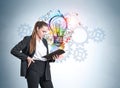 Businesswoman with notebook in hands with colourful light bulb and gears Royalty Free Stock Photo