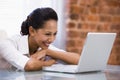 Businesswoman in office with laptop laughing Royalty Free Stock Photo