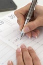 Businesswoman in office noting an appointment in her diary,