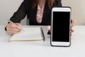 Businesswoman in office show smartphone in hands