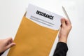 Businesswoman opening Insurance document in letter envelope