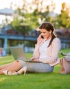 Businesswoman in park working on laptop, making phone call Royalty Free Stock Photo