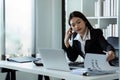 Businesswoman on the phone and using laptop at office. Businesswoman professional talking on mobile phone Royalty Free Stock Photo