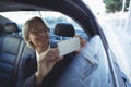 Businesswoman photographing in car