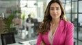 Businesswoman in a pink blazer with an office background Royalty Free Stock Photo