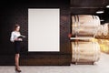 Black brick wine cellar, rows of kegs, woman Royalty Free Stock Photo