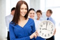 Businesswoman pointing at alarm clock