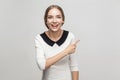 Businesswoman pointing finger at copy space, toothy smiling and Royalty Free Stock Photo