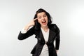Businesswoman pointing to head with an angry aggressive expression looking like a furious, crazy boss, wear black formal jacket Royalty Free Stock Photo