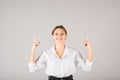 The businesswoman points her fingers up at the copy space for advertising on a gray background Royalty Free Stock Photo