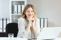 Businesswoman posing looking at you at office