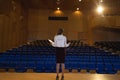 Businesswoman practicing and learning script while standing in the auditorium Royalty Free Stock Photo