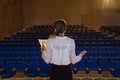 Businesswoman practicing and learning script while standing in the auditorium Royalty Free Stock Photo