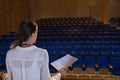 Businesswoman practicing and learning script while standing in the auditorium Royalty Free Stock Photo