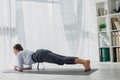Businesswoman practicing yoga in plank on mat in office