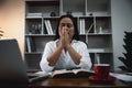 Businesswoman Praying with Eyes Closed. Businesswoman with her hands folded waiting for good news sitting at workplace at the Royalty Free Stock Photo