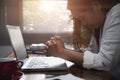 Businesswoman Praying with Eyes Closed. Businesswoman with her hands folded waiting for good news sitting at workplace at the Royalty Free Stock Photo