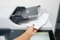 Businesswoman pull paper from the printer