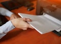 Businesswoman pull pieces of paper from the printer