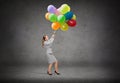 Businesswoman pulling down bunch of balloons