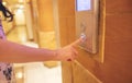 A businesswoman pushes the elevator button, her finger on the red button lift. tapping the control panel for the going down sign Royalty Free Stock Photo