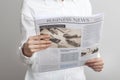 Businesswoman reading newspaper on gray background Royalty Free Stock Photo