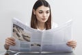 Businesswoman reading newspaper on gray background Royalty Free Stock Photo