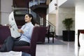 Businesswoman Reading Newspaper In Hotel Lobby Royalty Free Stock Photo