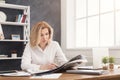 Businesswoman reading newspaper at office desktop Royalty Free Stock Photo