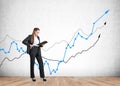 Businesswoman reading a notebook standing near rising stock market lines