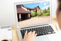 Businesswoman or real estate agent looking through online property portfolio using laptop