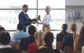 Businesswoman receiving award from businessman in a business seminar Royalty Free Stock Photo