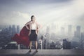 Businesswoman with red cape with modern city background