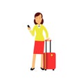 Businesswoman in red skirt and yellow blouse standing at airport with luggage and smartphone in hands. Business trip Royalty Free Stock Photo